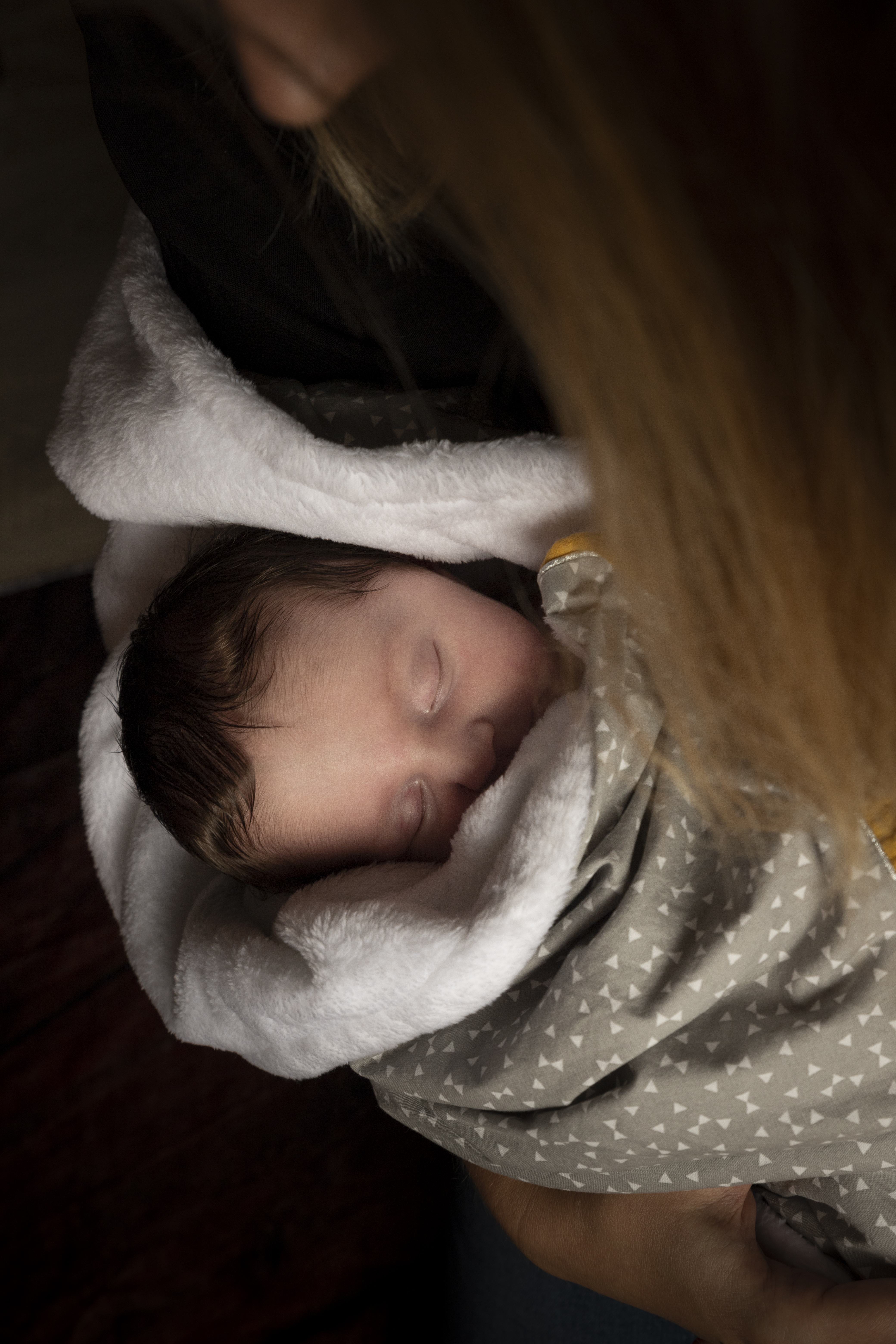 Portrait en gros plan d'un doux bébé endormi enveloppé dans une couverture blanche